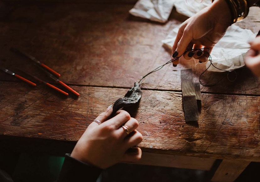 Woman making a bog oak necklace.
